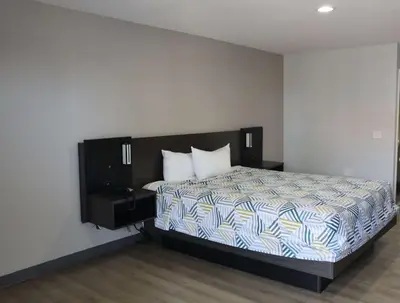 a bedroom with a bed with a blue and white comforter at Motel 6-San Diego, CA - Southbay in Chula Vista