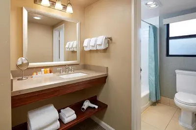 a bathroom with a sink and a toilet and a mirror at Glorietta Bay Inn in San Diego