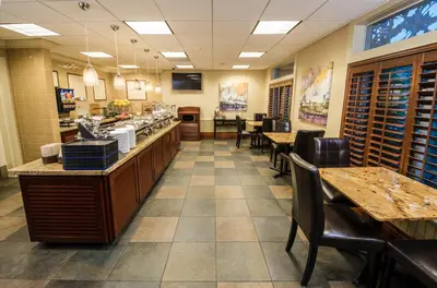 a restaurant with tables and chairs and a counter at West Inn & Suites in Carlsbad