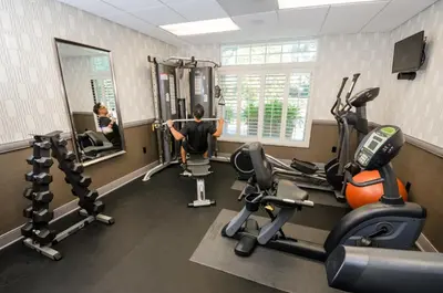 a man in a gym with several tread machines at West Inn & Suites in Carlsbad