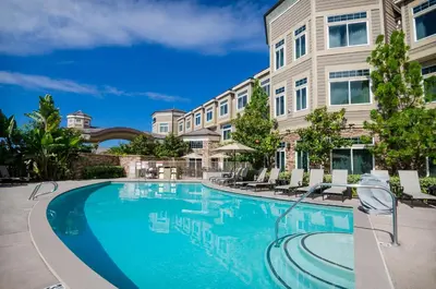a swimming pool in front of a building at West Inn & Suites in Carlsbad