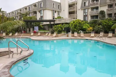 a large blue swimming pool with chairs and condos at North Coast Village Retreat B111 in Oceanside