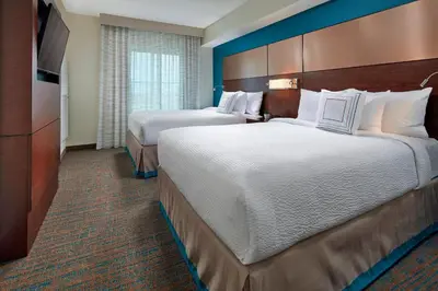 a hotel room with two beds and a television at Residence Inn by Marriott San Diego Chula Vista in Chula Vista