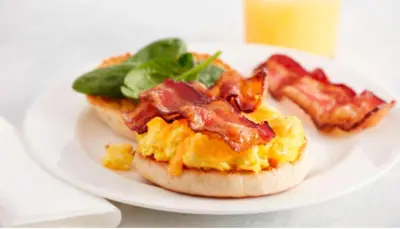 a white plate with two breakfast sandwiches with bacon at Residence Inn by Marriott San Diego Chula Vista in Chula Vista