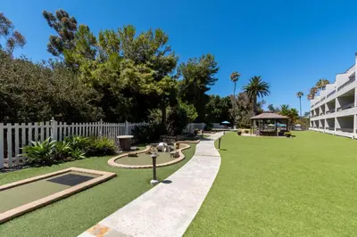 a garden with a white fence and a grass yard at San Clemente Inn in San Clemente
