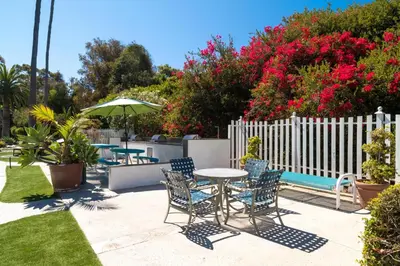 a patio with tables and chairs and a fence with flowers at San Clemente Inn in San Clemente