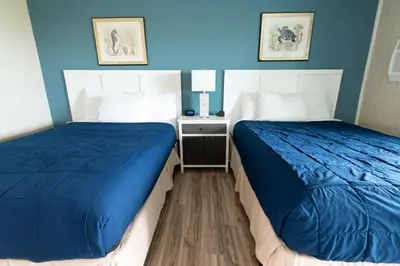 two beds in a room with blue walls at Ocean Villa Inn in San Diego