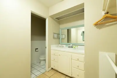 a bathroom with a toilet and a sink and a mirror at Ocean Villa Inn in San Diego