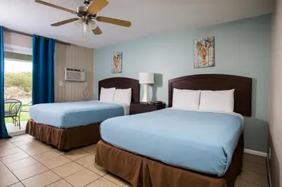 a hotel room with two beds and a ceiling fan at Ocean Villa Inn in San Diego