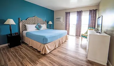 a bedroom with a bed and a blue wall at Ocean Villa Inn in San Diego
