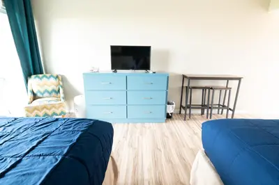 a bedroom with a blue dresser and a blue bed at Ocean Villa Inn in San Diego