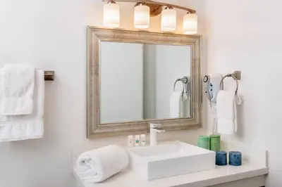 a bathroom with a white sink and a mirror at Beachfront Inn and Suites at Dana Point in Capistrano Beach