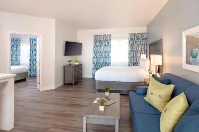 a hotel room with a blue couch and a bed at Beachfront Inn and Suites at Dana Point in Capistrano Beach