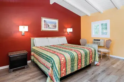 a bedroom with a bed and a red wall at Fallbrook Country Inn in Fallbrook