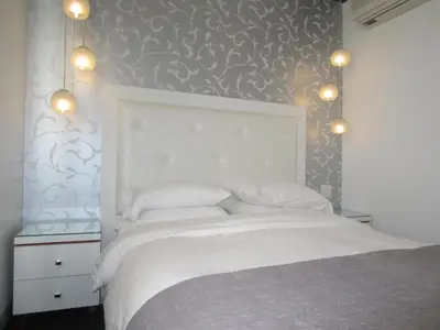 a bedroom with a white bed with a gray wall at La Pensione Hotel in San Diego