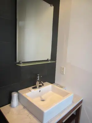 a bathroom with a white sink and a mirror at La Pensione Hotel in San Diego
