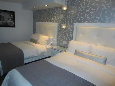 a bedroom with two beds and a wall mural at La Pensione Hotel in San Diego
