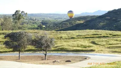 a hot air balloon is flying over a field at Mansion on the Hill let 4 Rooms, 5th cost extra in Sage