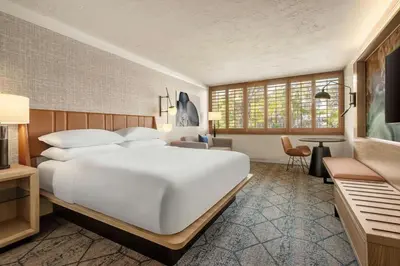 a bedroom with a large white bed and a desk at Sheraton La Jolla in San Diego