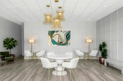 a waiting room with white chairs and a table and a painting at Sheraton La Jolla in San Diego