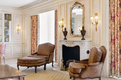 a living room with a fireplace and two chairs and a mirror at The Westgate Hotel in San Diego