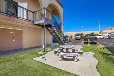 a picnic table in front of a building with a staircase at Motel Mediteran in Escondido