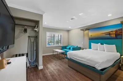 a hotel room with a bed and a television at Motel Mediteran in Escondido