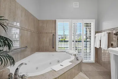 a large bathroom with a tub and a window at Motel Mediteran in Escondido