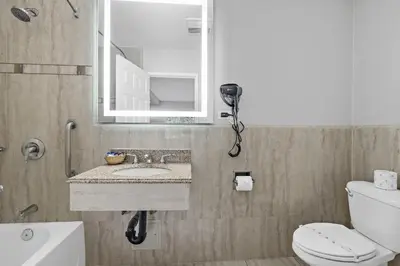 a bathroom with a sink and a mirror and a toilet at Motel Mediteran in Escondido