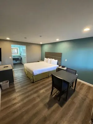 a hotel room with a bed and a table at Hotel Milagro in Chula Vista