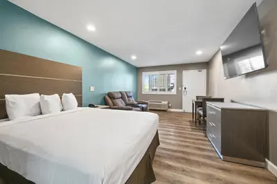 a hotel room with a large bed and a desk at Hotel Milagro in Chula Vista