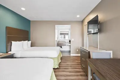 a hotel room with two beds and a television at Hotel Milagro in Chula Vista