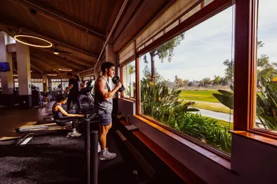 a man standing in a room looking out a window at a golf course at Guesthouse Hotel at La Valle in Rancho Santa Fe