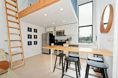 a kitchen with a wooden table and stools at New Beach House, Steps to Sand in San Diego