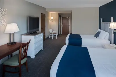 a hotel room with two beds and a desk and a television at Bay Club Hotel and Marina in San Diego