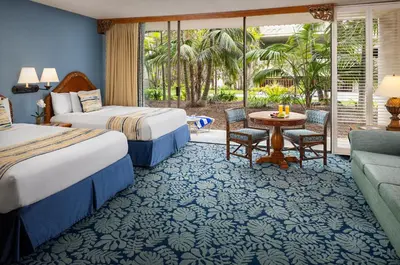 a hotel room with two beds and a patio at Catamaran Resort Hotel and Spa in San Diego