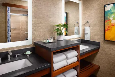 a bathroom with two sinks and two mirrors at Catamaran Resort Hotel and Spa in San Diego