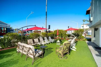 a row of chairs and tables on a lawn at Little Inn By The Bay Newport Beach Hotel in Newport Beach