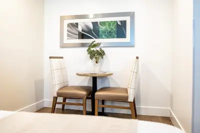 a table and two chairs with a plant on it at Little Inn By The Bay Newport Beach Hotel in Newport Beach