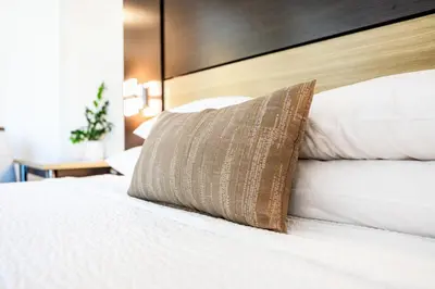 a bed with a pillow on top of it at Little Inn By The Bay Newport Beach Hotel in Newport Beach