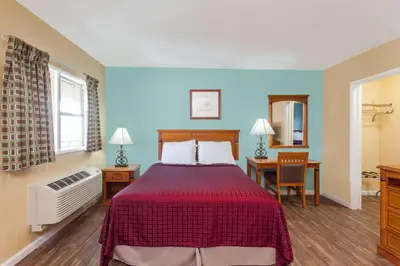 a hotel room with a bed and a desk at Travelodge by Wyndham San Diego SeaWorld in San Diego