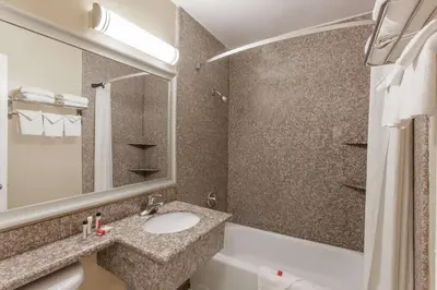 a bathroom with a sink and a toilet and a tub at Travelodge by Wyndham San Diego SeaWorld in San Diego