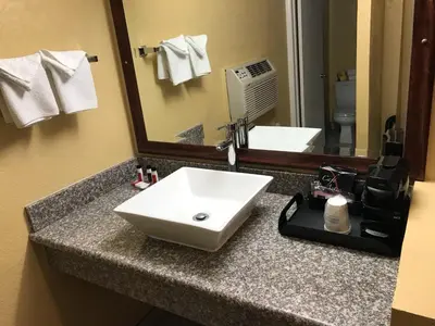 a bathroom counter with a sink and a mirror at Travelodge by Wyndham San Diego SeaWorld in San Diego