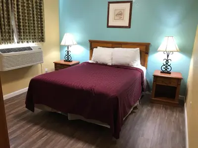 a bedroom with a bed and two night stands with lamps at Travelodge by Wyndham San Diego SeaWorld in San Diego