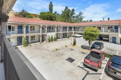 an apartment building with cars parked in a parking lot at Motel 6-La Mesa, CA in San Diego