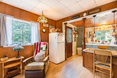 a kitchen with wooden walls and a white refrigerator at Time Traveler Retreat in Julian
