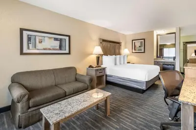 a hotel room with a bed and a couch at Best Western Americana Inn in San Ysidro, San Diego