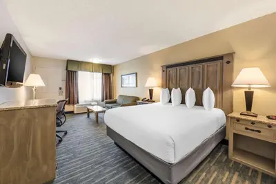 a hotel room with a large bed and a living room at Best Western Americana Inn in San Ysidro, San Diego