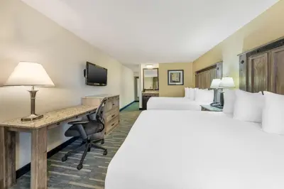 a hotel room with two beds and a desk at Best Western Americana Inn in San Ysidro, San Diego