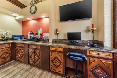a hotel room with a bar with a tv on the wall at Best Western Americana Inn in San Ysidro, San Diego